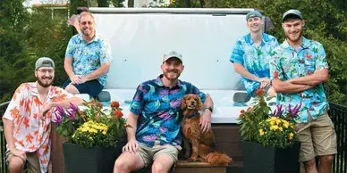The Spa Guys are lined up in front of a hot tub